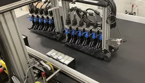A line of l-series printheads from Matthews Marking Solutions on a conveyor belt built in-line for marking and coding.